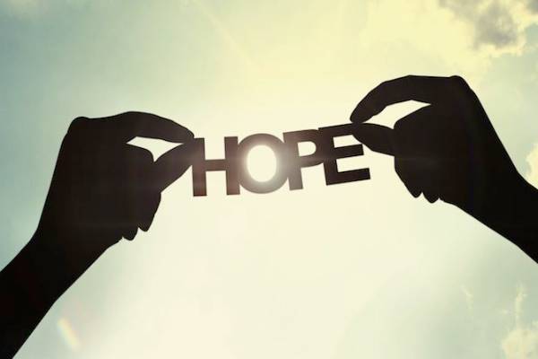 Two hands holding the word hope