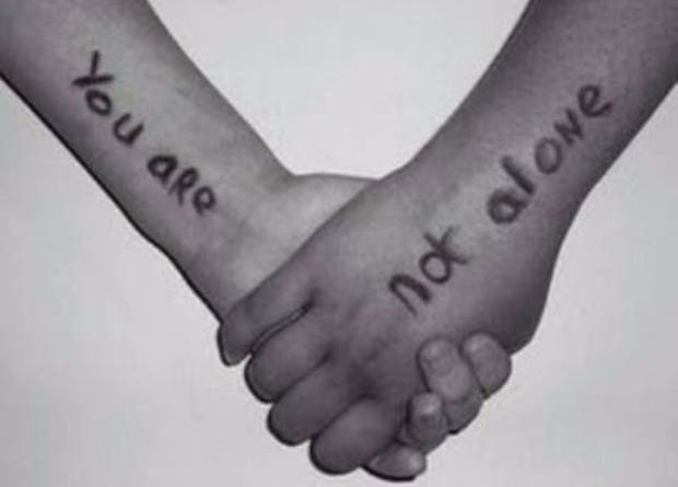 Holding hands with You Are not alone written on the arms